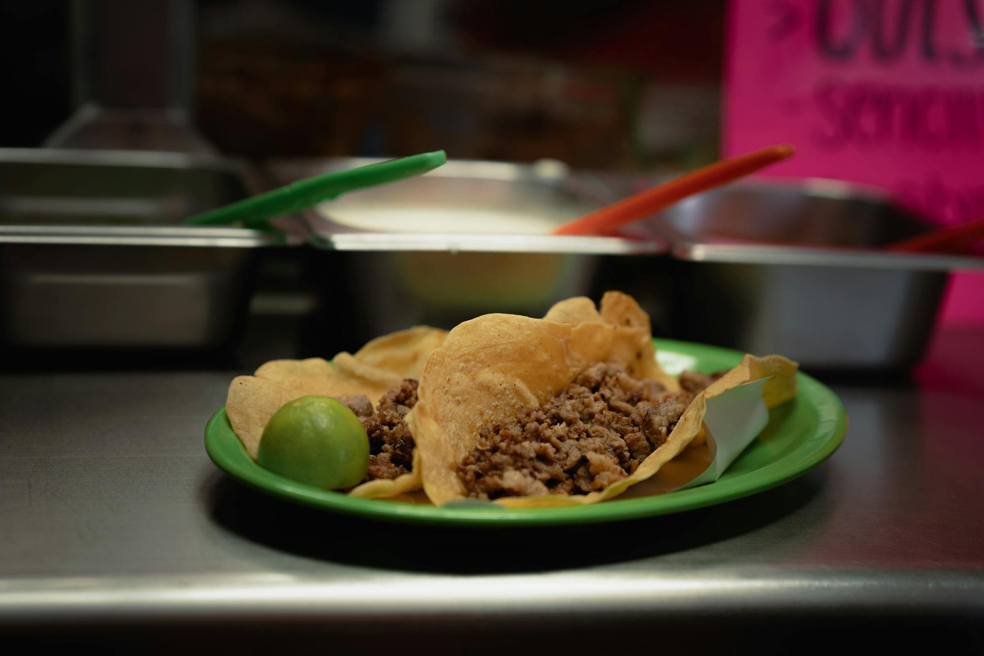 Tacos with meat and lime served on a green plate