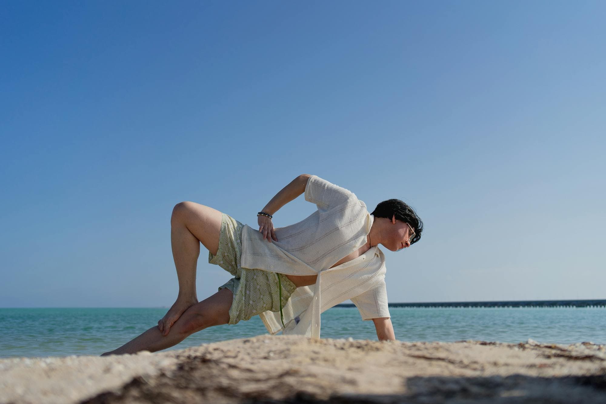 A woman practicing yoga on a Mexican beach at sunrise