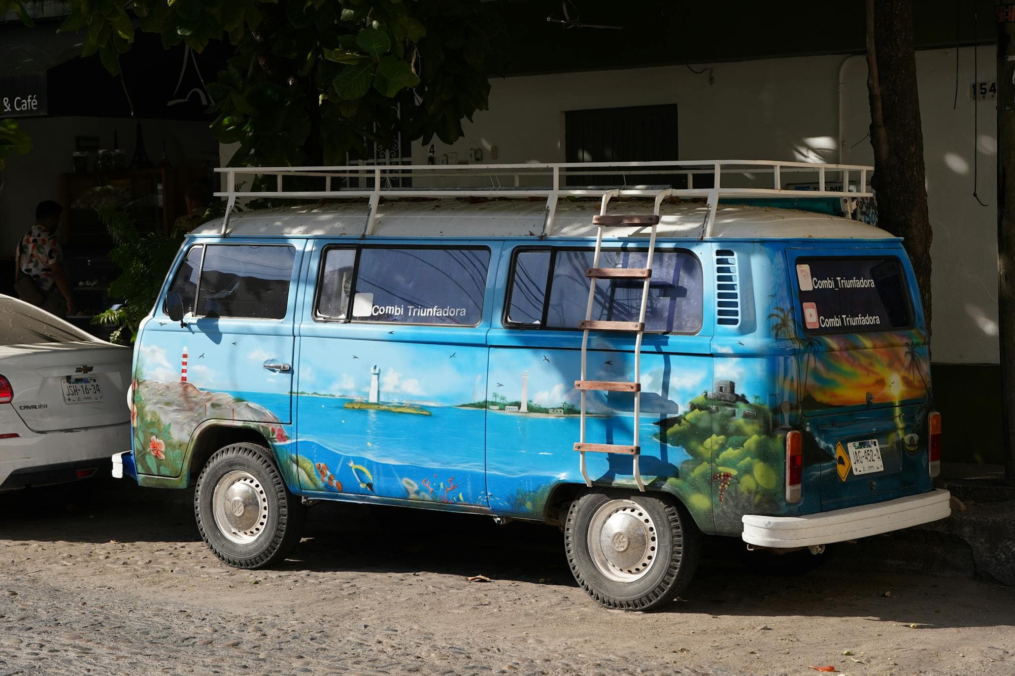 A graffiti-painted VW van on a sunny Puerto Vallarta street